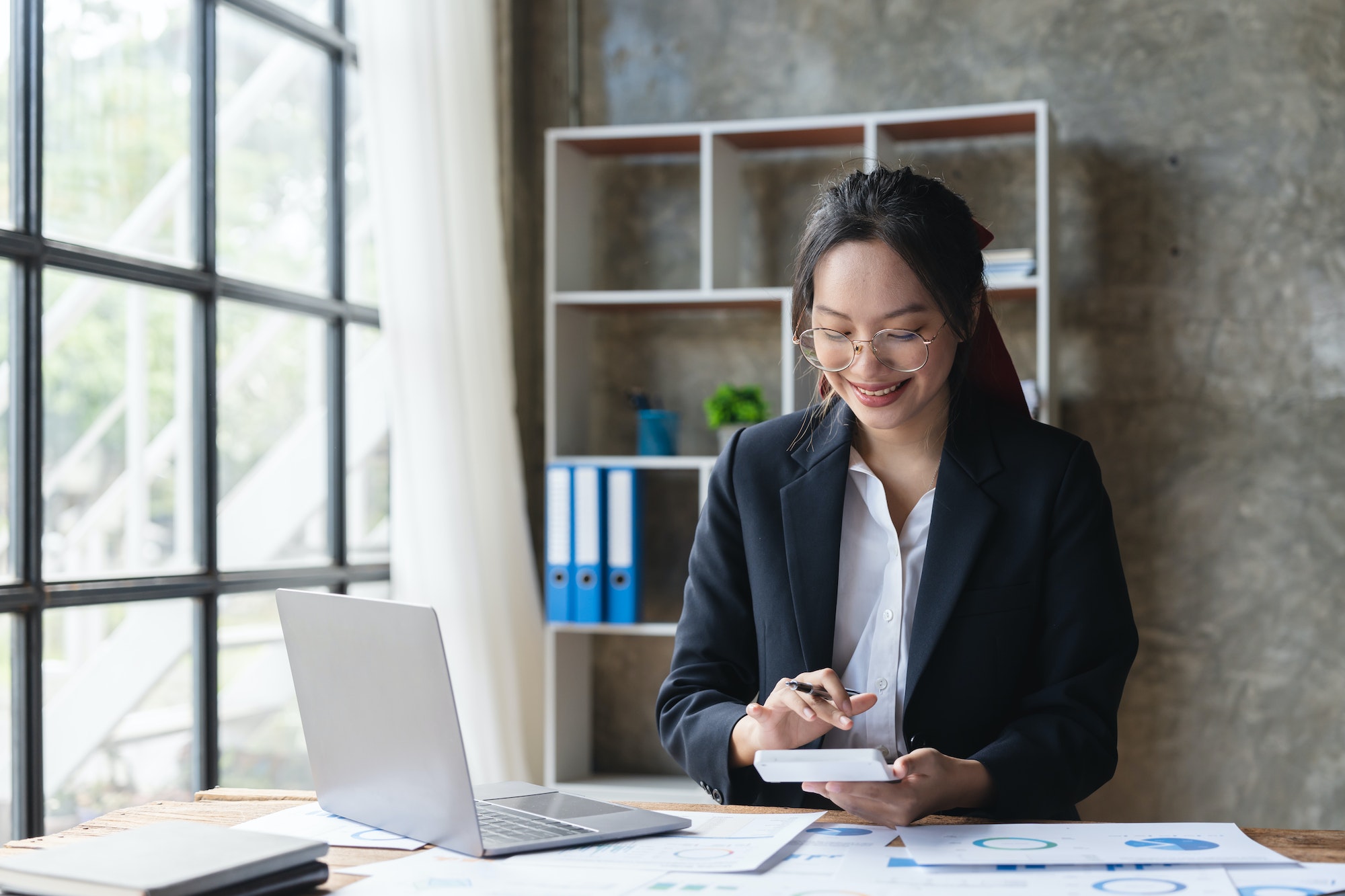 Asian woman accountant working with computer and calculator for business and financial expense